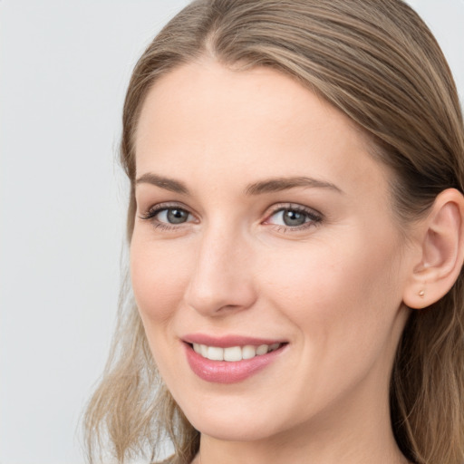 Joyful white young-adult female with long  brown hair and grey eyes