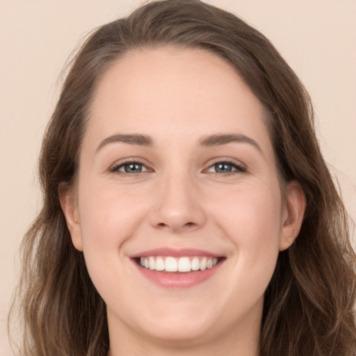 Joyful white young-adult female with long  brown hair and grey eyes