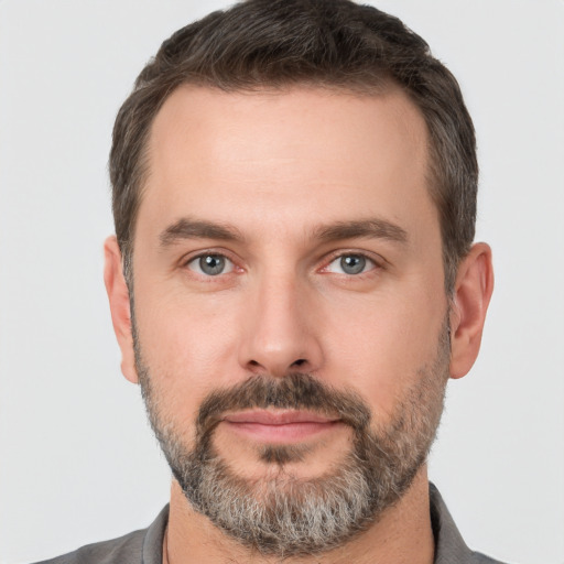 Joyful white adult male with short  brown hair and brown eyes