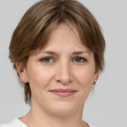 Joyful white adult female with medium  brown hair and grey eyes