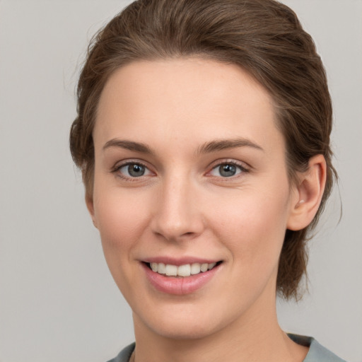 Joyful white young-adult female with medium  brown hair and grey eyes