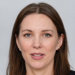 Joyful white adult female with long  brown hair and grey eyes