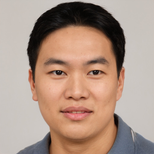 Joyful asian young-adult male with short  black hair and brown eyes