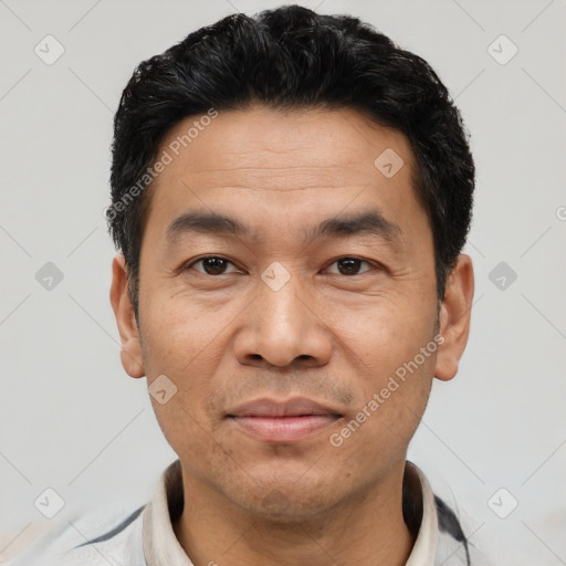 Joyful asian adult male with short  black hair and brown eyes