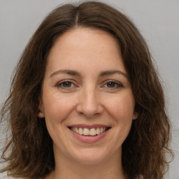 Joyful white adult female with long  brown hair and brown eyes