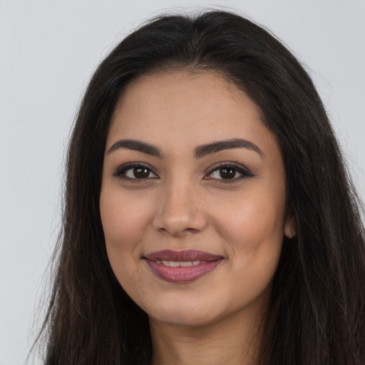 Joyful latino young-adult female with long  brown hair and brown eyes