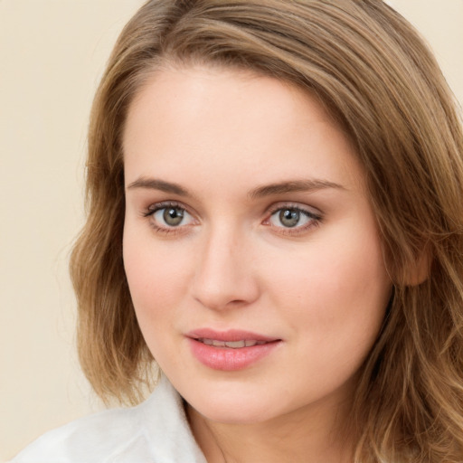 Joyful white young-adult female with long  brown hair and green eyes