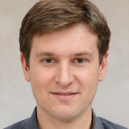 Joyful white young-adult male with short  brown hair and grey eyes