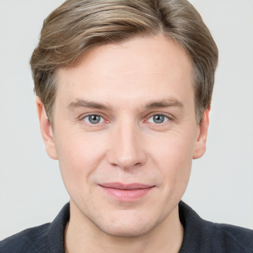 Joyful white young-adult male with short  brown hair and grey eyes