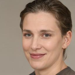 Joyful white adult female with medium  brown hair and grey eyes