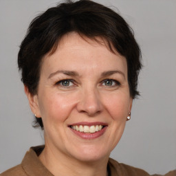 Joyful white adult female with medium  brown hair and grey eyes