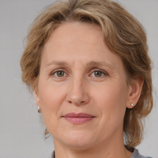 Joyful white adult female with medium  brown hair and grey eyes