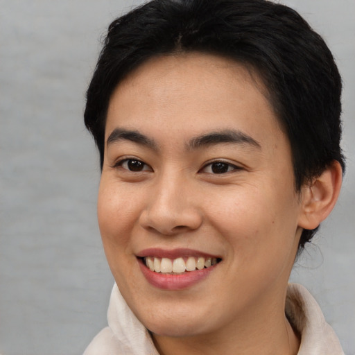 Joyful asian young-adult female with short  brown hair and brown eyes