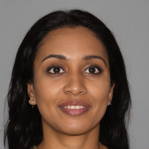 Joyful black young-adult female with long  brown hair and brown eyes