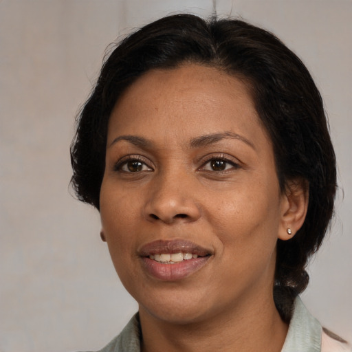 Joyful black adult female with medium  brown hair and brown eyes