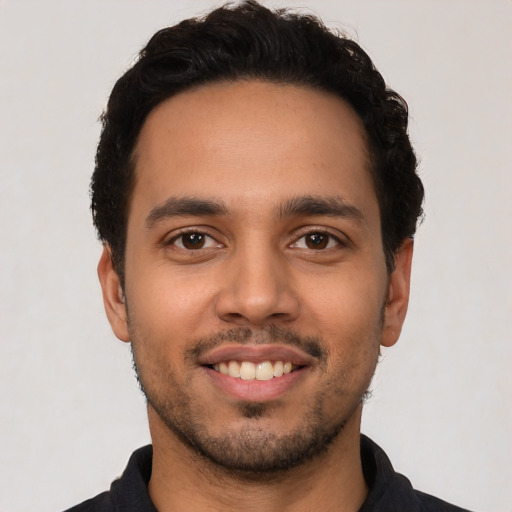 Joyful latino young-adult male with short  black hair and brown eyes
