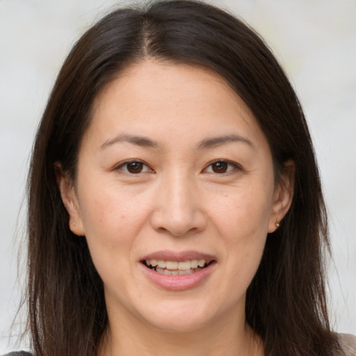 Joyful white adult female with long  brown hair and brown eyes