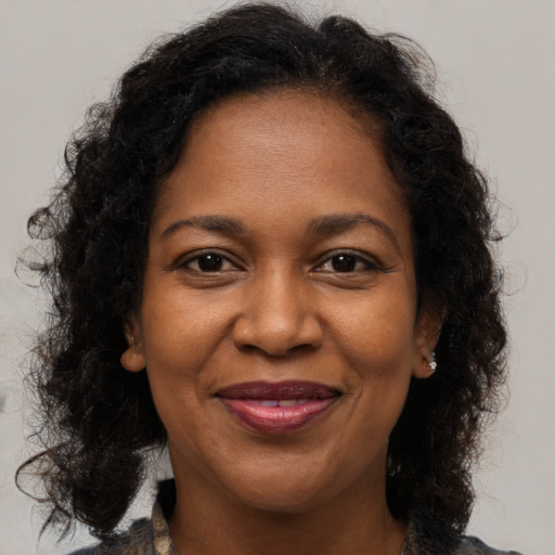Joyful black adult female with medium  brown hair and brown eyes