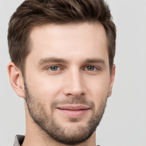 Joyful white young-adult male with short  brown hair and grey eyes