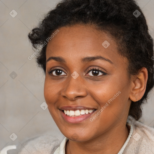 Joyful black young-adult female with short  brown hair and brown eyes