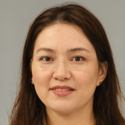 Joyful white adult female with long  brown hair and brown eyes