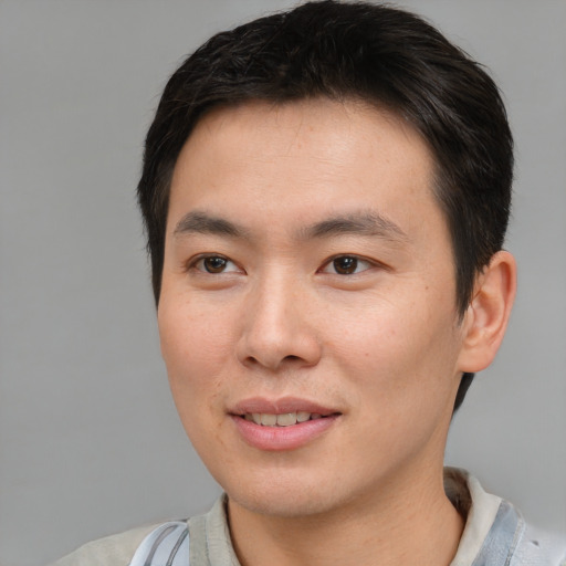 Joyful asian young-adult male with short  brown hair and brown eyes