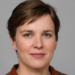 Joyful white adult female with medium  brown hair and grey eyes