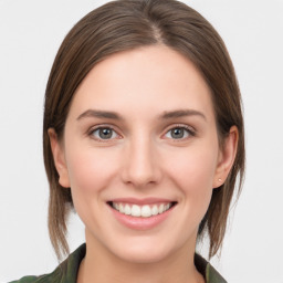 Joyful white young-adult female with medium  brown hair and green eyes