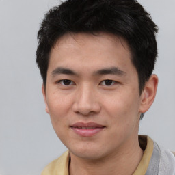 Joyful asian young-adult male with short  brown hair and brown eyes