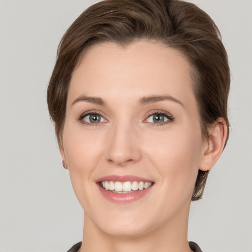 Joyful white young-adult female with medium  brown hair and grey eyes