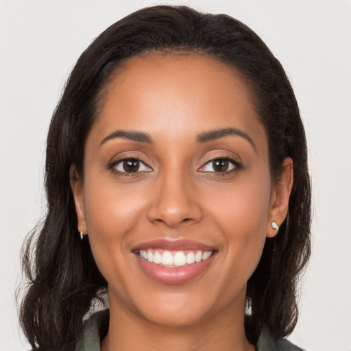 Joyful latino young-adult female with long  brown hair and brown eyes