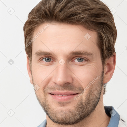 Joyful white young-adult male with short  brown hair and grey eyes