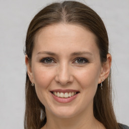 Joyful white young-adult female with long  brown hair and grey eyes