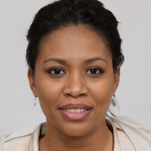 Joyful black young-adult female with short  brown hair and brown eyes