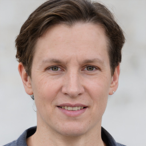 Joyful white adult male with short  brown hair and grey eyes