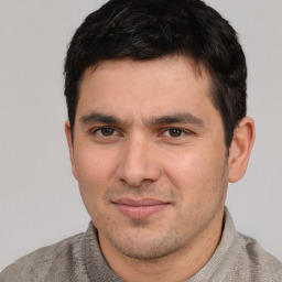 Joyful white young-adult male with short  black hair and brown eyes