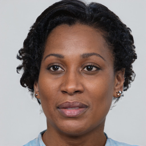Joyful black adult female with short  black hair and brown eyes