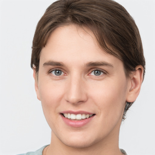 Joyful white young-adult female with short  brown hair and grey eyes