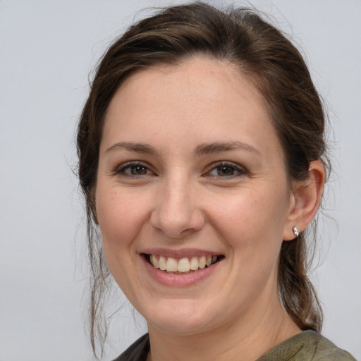 Joyful white young-adult female with medium  brown hair and grey eyes