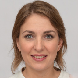 Joyful white adult female with medium  brown hair and grey eyes