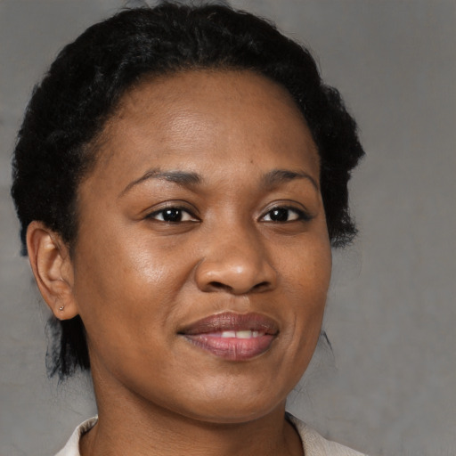 Joyful black adult female with short  brown hair and brown eyes
