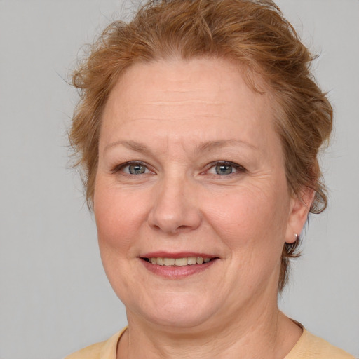 Joyful white adult female with medium  brown hair and blue eyes