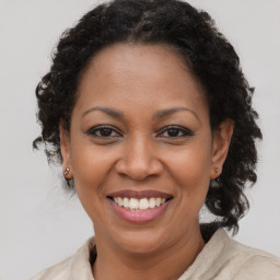 Joyful black adult female with medium  brown hair and brown eyes