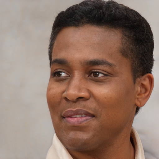 Joyful black young-adult male with short  brown hair and brown eyes