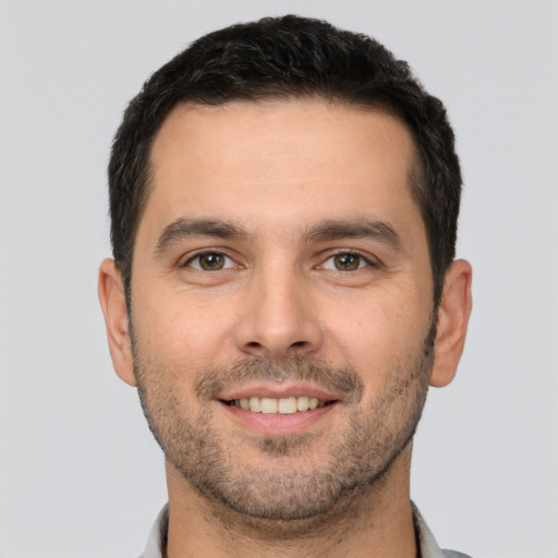 Joyful white young-adult male with short  brown hair and brown eyes