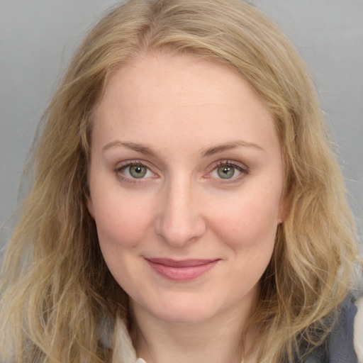 Joyful white young-adult female with long  brown hair and blue eyes