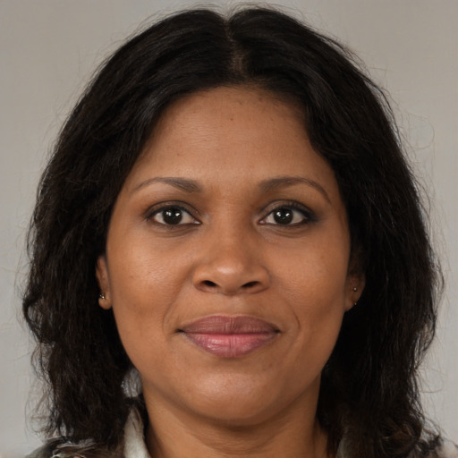 Joyful black adult female with long  brown hair and brown eyes