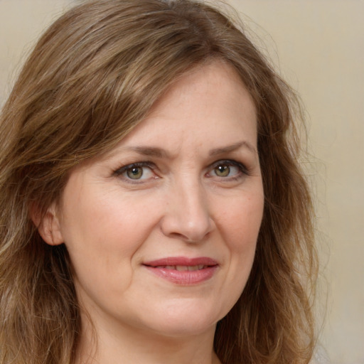 Joyful white adult female with long  brown hair and green eyes