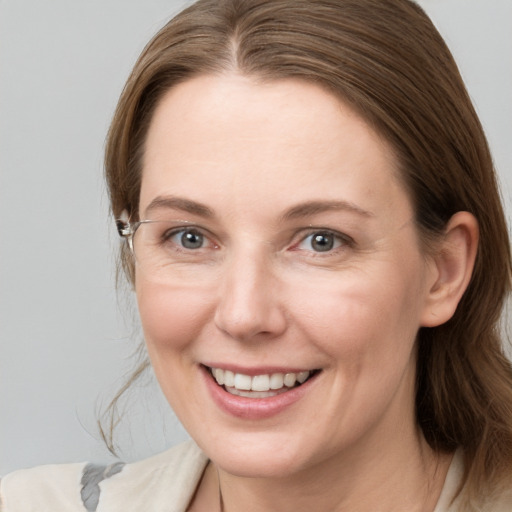 Joyful white young-adult female with medium  brown hair and grey eyes