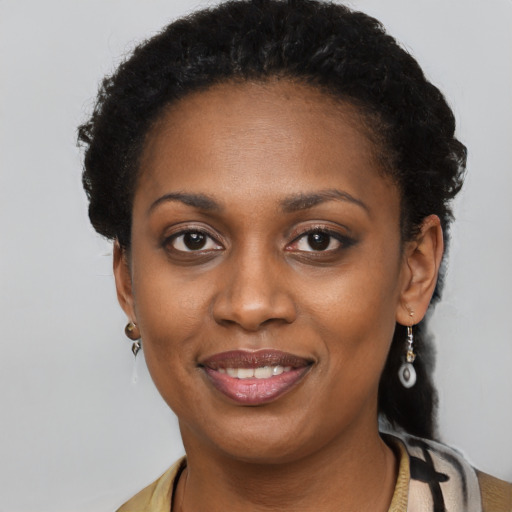 Joyful black young-adult female with short  black hair and brown eyes